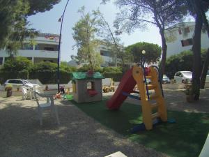 a playground with a slide and a swing at APPARTAMENTO MARETRAMONTO IN RESIDENCE MAREBLU in Nocera Terinese