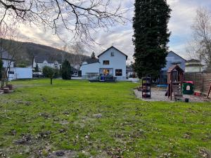 a yard with a white house and a playground at Ferienwohnung in Rheinnähe in Rheinbreitbach
