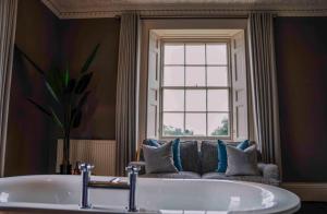 baño con bañera y ventana en St Anne's Manor - Luxury Villa with Hot Tub, en Torquay