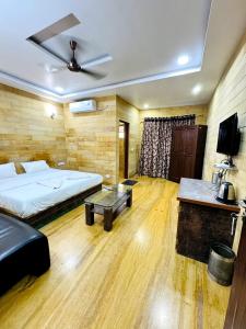 a bedroom with a bed and a table and a tv at Abu Safari Jaisalmer Hostel & Hotel in Jaisalmer