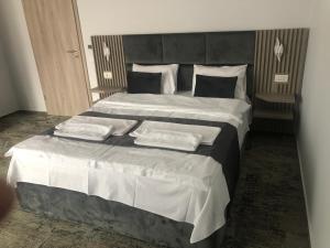 a bedroom with a large bed with two pillows at Sub Cetate in Râşnov