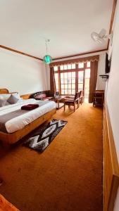 a bedroom with a large bed in a room at Manali Heritage Hotel in Manāli