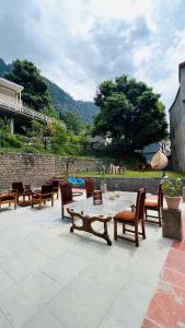 a patio with a bunch of chairs and tables at Manali Heritage Hotel in Manāli