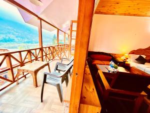 a room with a balcony with a bed and a table at Manali Heritage Hotel in Manāli