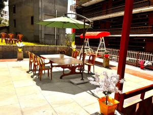 - une table, des chaises et un parasol sur la terrasse dans l'établissement Manali Heritage Hotel, à Manali