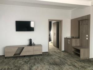 a living room with a television and a wooden cabinet at Sub Cetate in Râşnov