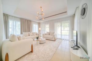 una sala de estar con muebles y ventanas blancos. en Luxury 3BR Villa with Assistant Room at Alvorada 4 Arabian Ranches by Deluxe Holiday Homes, en Dubái