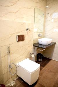 a bathroom with a white toilet and a sink at The Serene Woods Resort in Matkuli