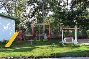 a playground with two swings and a slide at The Serene Woods Resort in Matkuli