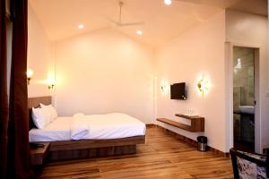a bedroom with a bed and a sink and a mirror at The Serene Woods Resort in Matkuli
