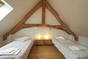 2 Betten in einem Zimmer mit Dach in der Unterkunft Havre de paix proche de Bagnoles de l'Orne in Saint-Michel-des-Andaines