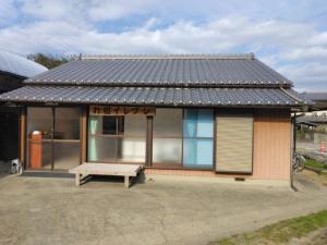a small house with a bench in front of it at お宿イレブン in Yoshinogawa