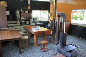 a kitchen with a wooden table and a stove at お宿イレブン in Yoshinogawa