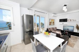 a kitchen and living room with a table and a refrigerator at Jimi Apartments 2 in Vlorë