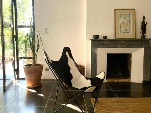 Val-de-DagneにあるLe Pavillon Du Regisseurの暖炉付きのリビングルームの黒い椅子