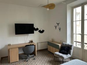 a room with a desk and a television on a wall at notre dame des anges in Lurs