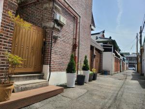 um edifício de tijolos com vasos de plantas numa rua em City Central & Cosy House em Gwangju