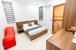 una camera con letto e sedia rossa di Khách sạn Vạn Phúc - Yên Bái a Xóm Soi (2)