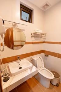 bagno con lavandino, servizi igienici e specchio di Khách sạn Vạn Phúc - Yên Bái a Xóm Soi (2)