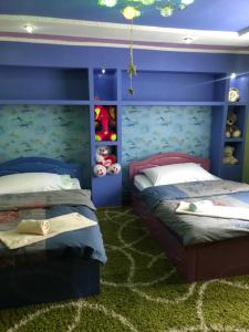 two beds in a bedroom with blue walls at У Ані in Lazeshchyna