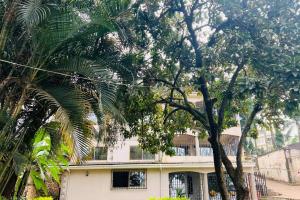 uma casa branca com palmeiras em frente em Cozy Living by Miranda, Acacia - 2 BDR, 4 beds, 3 Bthrms, Unlimited WIFI, Free Parking, Netflix em Kampala