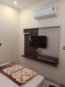 een kamer met een flatscreen-tv aan de muur bij Hotel Raj 2 KM from Janana Hospital and 1 KM from MDS University in Ajmer