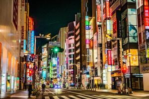 eine belebte Stadtstraße nachts mit Neonschildern in der Unterkunft APA Hotel - Higashishinjuku Kabukicho Higashi in Tokio