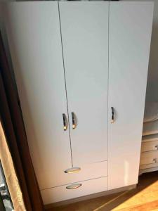 a white cabinet with silver handles in a kitchen at Cosy 1+1 in Istanbul