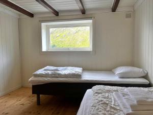 1 dormitorio con 2 camas y ventana en Lofoten Fjord Apartment - Kvalvika Beach & Ryten, 
