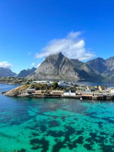 un'isola in acqua con una montagna sullo sfondo di Lofoten Fjord Apartment - Kvalvika Beach & Ryten 