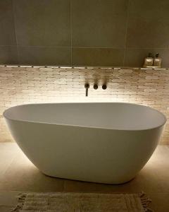 a large white bath tub in a bathroom at The_Kennedy_house in Bilinga