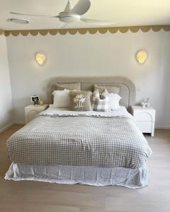 a white bedroom with a large bed with pillows at The_Kennedy_house in Bilinga