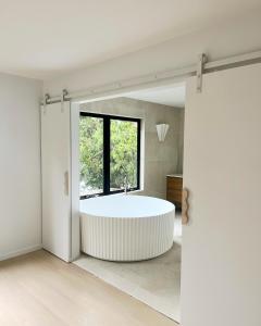 a bathtub in a bathroom with a large window at The_Kennedy_house in Bilinga