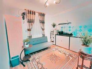 a living room with a blue couch and a kitchen at Căn hộ Studio-Banana Homestay in Hue