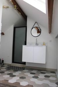 ein weißes Badezimmer mit einem Waschbecken und einem Spiegel in der Unterkunft Belle maison normande avec hamam sauna jacuzi in Saint-Pierre-de-Cormeilles