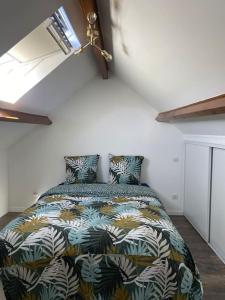 1 dormitorio con 1 cama con un edredón colorido en Belle maison normande avec hamam sauna jacuzi, en Saint-Pierre-de-Cormeilles
