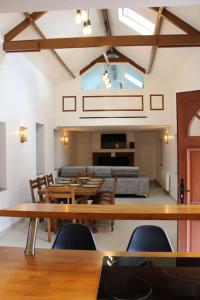uma sala de jantar com mesas e cadeiras de madeira em Belle maison normande avec hamam sauna jacuzi em Saint-Pierre-de-Cormeilles