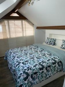 a bedroom with a bed with a blue and white blanket at Belle maison normande avec hamam sauna jacuzi in Saint-Pierre-de-Cormeilles