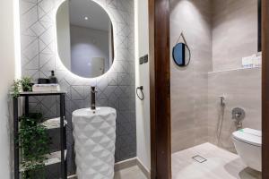 a bathroom with a toilet and a mirror at Amber Hospitality - Al Nafel in Riyadh