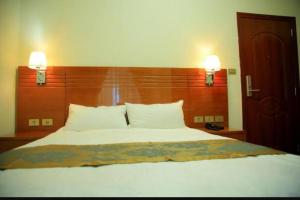 a bedroom with a large bed with two lights on the wall at Armah International Hotel in Āksum
