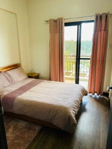 バギオにあるYourHomeAway,LuxFlat at BristleRidge Baguioのベッドルーム1室(ベッド1台、大きな窓付)