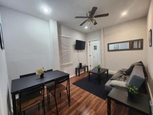 a living room with a table and a couch and a ceiling fan at Prime Location 3-Bed Close to NYC in Jersey City