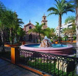 une fontaine en face d'un bâtiment avec une église dans l'établissement Modern 2 bedroom apartment in the center of Torrevieja, à Torrevieja