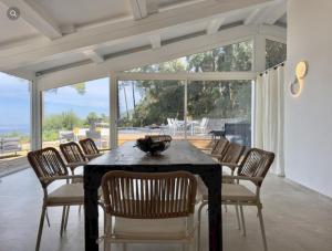 a dining room with a black table and chairs at Villa Ormarine, vue exceptionnelle sur la baie de Cannes et le Mercantour in Les Adrets de l'Esterel