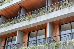 un edificio de oficinas con ventanas y plantas en los balcones en Casacotta, en Seminyak