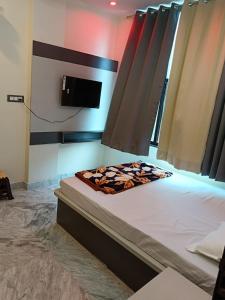a bedroom with a bed with a tv on the wall at Hotel Raj 2 KM from Janana Hospital and 1 KM from MDS University in Ajmer