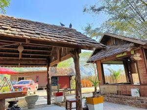 een houten paviljoen met een auto op een binnenplaats bij Cool Pool Bungalow in Ban Phônmuang