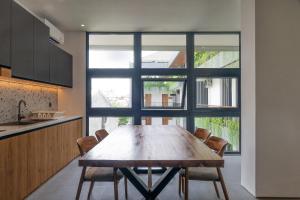 a wooden table in a kitchen with a large window at Casacotta in Seminyak