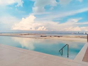 einen Pool mit Blick auf den Strand in der Unterkunft Penang Amazing SeaView Private Lift 梹城富人区绝美海景公寓私人电梯 in Tanjong Tokong