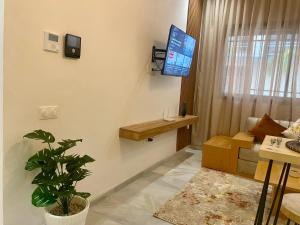 uma sala de estar com televisão na parede em Élégance en 40 mètres Nouaceur em Nouaceur